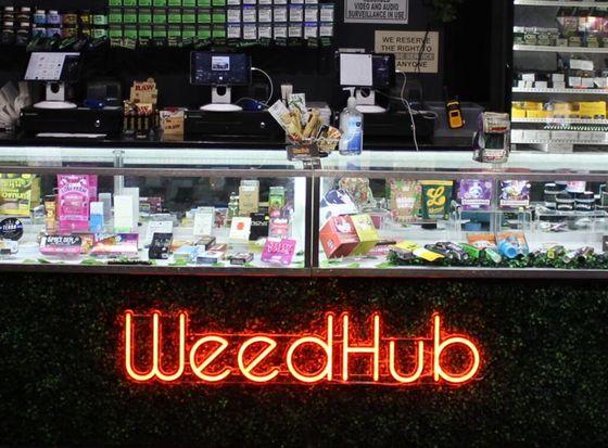 The lit Weedhub sign on the counter at 3407 Geary Blvd